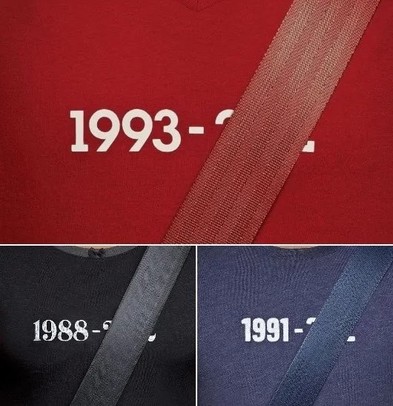 A sweater depicting a birth date and a death date. The death date is cowered by seatbelt indicating that the person wearing the seatbelt didn't die