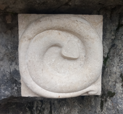 The "button" (a square sign made of stone with a spiraling snake on it).