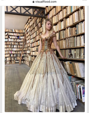 A model poses in a gorgeous dress with a bodice patterned as book covers and the flaring skirt resembling printed pages.