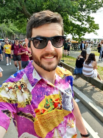 Paul wearing a Hawaiian shirt with a bunch of cats in tacos arranged on a space pattern.
