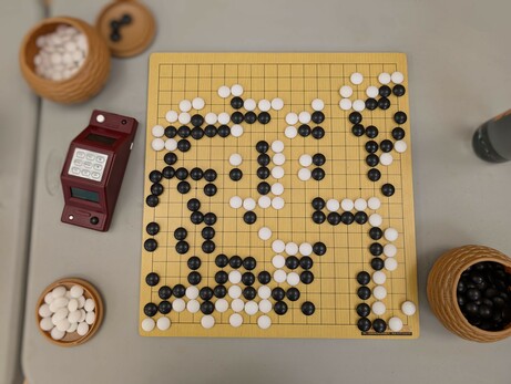A Go game. White has resigned after black captured a pile of stones, killing even more.