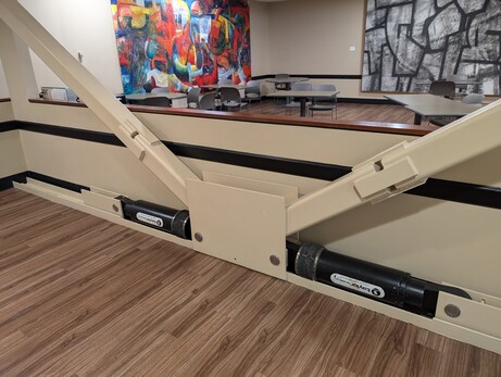 Some girders(?) in a building, attached to what look like huge shock absorbers, labeled "viscous damping device".